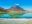 A still, emerald, turquoise lake in front of a volcano