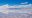 Vast salt flats interspersed with little cones of salt under a blue sky dotted with cloud tufts