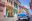 Vintage classic American car parked in street lined in two storey buildings painted in pastel colours